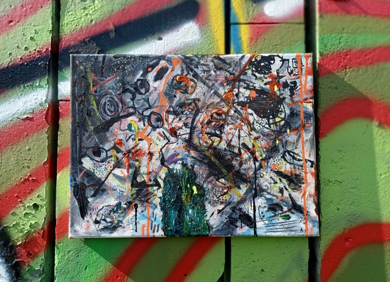 May include: Abstract painting on canvas with black, white, orange, green, and blue paint splatters and brushstrokes.