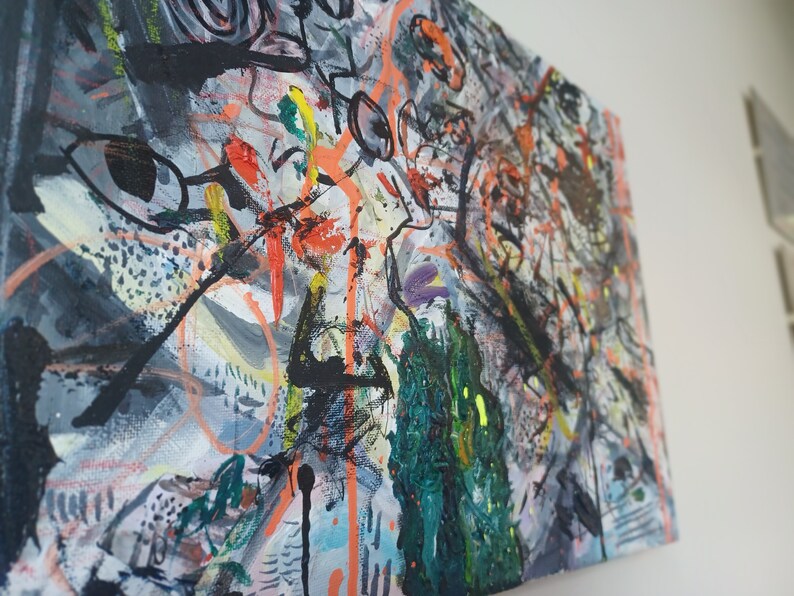 May include: Abstract painting on canvas with a mix of black, white, orange, green, and purple paint. The painting has a chaotic and energetic feel.