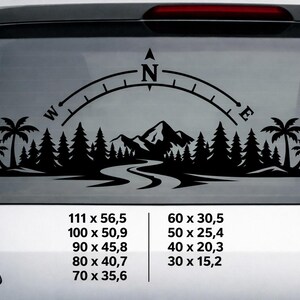 May include: A black vinyl decal featuring a compass rose arching over a landscape of pine trees, palm trees, and mountains with a winding river. The text displays various dimensions in centimetres: 111 x 56.5, 100 x 50.9, 90 x 45.8, 80 x 40.7, 70 x 35.6, 60 x 30.5, 50 x 25.4, 40 x 20.3, and 30 x 15.2.
