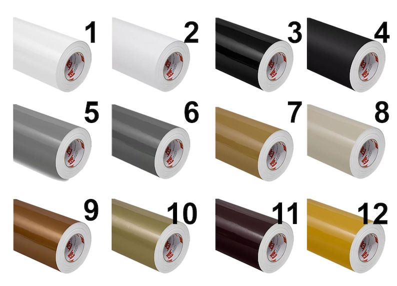 May include: A grid of twelve rolls of adhesive vinyl film, each labeled with a number from 1 to 12. The rolls display a variety of solid colors including white, black, gray, beige, brown, gold, and yellow, all featuring a white inner core.