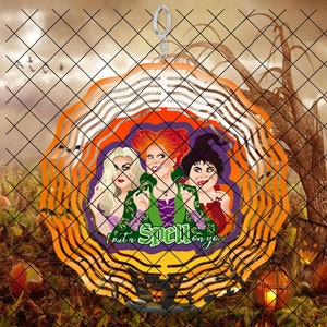 May include: A colorful, layered, metal wind spinner featuring three witches from the movie Hocus Pocus. The witches are depicted in their iconic costumes and the spinner has the text "I put a spell on you".
