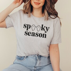 May include: A gray t-shirt with the text "spooky season" in black lettering and three small ghost illustrations.