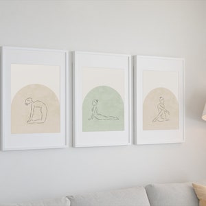 May include: Three framed prints with minimalist line drawings of people in yoga poses. Each print features a different pose and a muted background color.