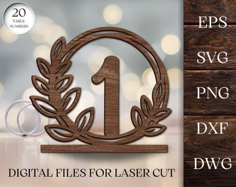 May include: A set of 20 laser cut table numbers for a wedding or special event. Each number is a circle with a laurel wreath design and a large number in the center. The numbers are made of wood and are available in EPS, SVG, PNG, DXF, and DWG formats.