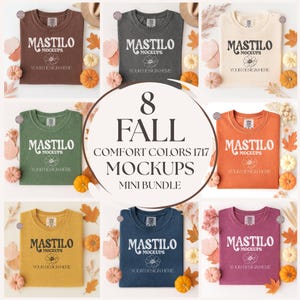 Può includere: Una collezione di otto mockup di magliette a tema autunnale in vari colori, tra cui marrone, grigio, crema, arancione, verde, giallo, blu navy e bordeaux. Ogni maglietta mostra il logo "MASTILO MOCKUPS" e il testo "YOUR DESIGN HERE". L'immagine è decorata con zucche e foglie autunnali.