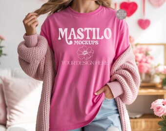 May include: A pink long-sleeve t-shirt with the text "MASTILO MOCKUPS" and a floral graphic. The shirt is worn with a pink cardigan and blue denim shorts. The image is a mockup for apparel designs.