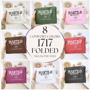 May include: A mockup bundle featuring eight folded t-shirts in various colors, including beige, green, pink, brown, red, purple, white, and gray. Each shirt displays the "MASTILO MOCKUPS" logo and the text "YOUR DESIGN HERE". The image includes the text "8 COMFORT COLORS 1717 FOLDED MOCKUP BUNDLE".