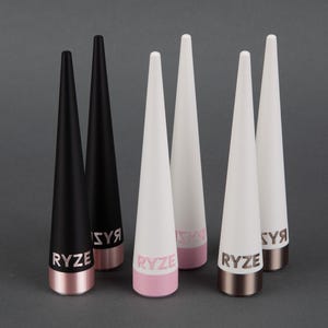 May include: Six conical display stands arranged in a group. Two are matte black with metallic copper bases, two are matte white with metallic pink bases, and two are matte white with metallic bronze bases. Each stand features the word RYZE in capital letters.