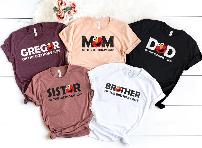 May include: Five t-shirts in various colors, each with a different family member's name and the phrase "of the birthday boy." The designs include the character Elmo.