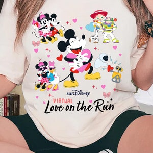 May include: A white t-shirt with a colorful graphic of Mickey Mouse and other Disney characters. The text "runDisney Virtual Love on the Run" is printed on the shirt.
