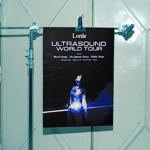 Könnte beinhalten: Ein schwarzes Poster für Lordes Ultrasound World Tour mit einem Foto der Künstlerin. Das Poster enthält den Tournamen und die Namen der Support-Acts: Blood Orange, The Japanese House, Nilufer Yanya, Chanel Beads, Empress Of und Jan-Stack.