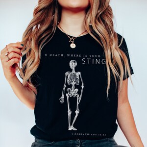 May include: Black t-shirt with a white skeleton graphic and the text "O Death, Where Is Your Sting?"  1 Corinthians 15:55.