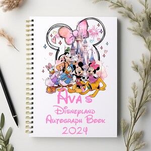 May include: A pink and white autograph book with a Disney theme. The cover features Mickey Mouse, Minnie Mouse, Donald Duck, Goofy, Pluto, and Cinderella's castle. The book says "Ava's Disneyland Autograph Book 2024".