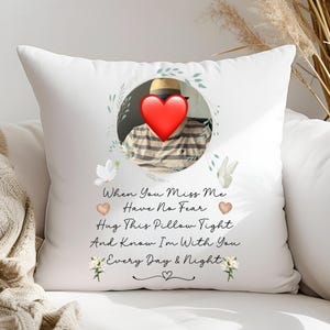 May include: White throw pillow with a floral wreath design and a photo of a person wearing a hat. The text "When You Miss Me Have No Fear Hug This Pillow Tight And Know I'm With You Every Day & Night" is printed on the pillow.