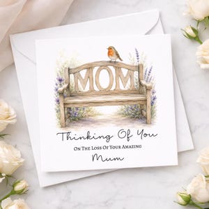 May include: A square greeting card featuring a watercolor illustration of a wooden bench with the word MOM carved into the backrest. A small robin sits on top of the bench, surrounded by purple lavender flowers. The text reads Thinking Of You ON THE LOSS OF YOUR AMAZING Mum.