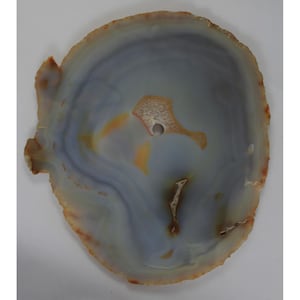 May include: A polished agate slice with a natural, organic shape. The stone features a blend of blue, gray, orange, and brown hues, with a central hole. The edges have a rough, textured appearance. This decorative piece is suitable for home decor.