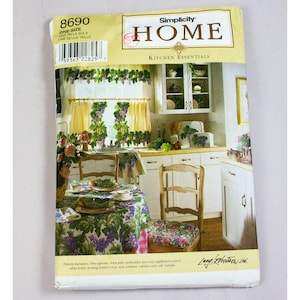 May include: Simplicity Home Kitchen Essentials pattern. The image shows a kitchen scene with matching curtains, tablecloth, and seat cushions featuring a grape design. The pattern includes aprons, oven mitts, and other kitchen accessories.