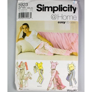 May include: Simplicity @Home easy-to-sew pattern 5923 for juniors sizes AA, S, M, L, XL. The pattern includes instructions for making pajamas with a variety of tops and bottoms. The model is wearing a white top with a pink and white patterned bottom.