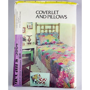 Könnte beinhalten: Ein Vintage-Nähmuster von McCall's für eine Patchwork-Bettdecke und Kissen. Das Muster ist für ein Einzel- oder Doppelbett und zeigt ein farbenfrohes Patchwork-Design mit einem Blumendruck. Das Muster trägt den Titel "Coverlet and Pillows" und die Nummer 3004.