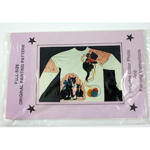 May include: A full-size original painting pattern featuring a white long-sleeved shirt with three black cats and a ball of yarn. The pattern includes a color photo and painting instructions.  The text on the package reads "Full-Size Original Painting Pattern" and "Includes Color Photo And Painting Instructions".