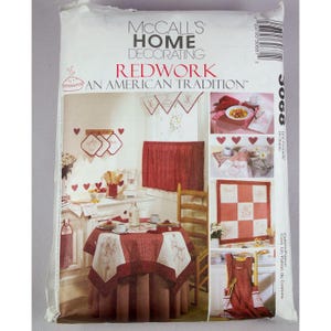 May include: A McCall's Home Decorating sewing pattern envelope titled Redwork An American Tradition 3068. The package features photographs of red and white embroidered kitchen textiles, including a tablecloth, valance, and wall hangings.
