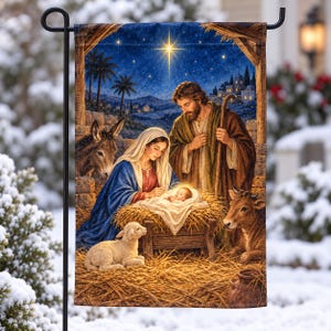 May include: A rectangular garden flag featuring a nativity scene with a woman in a blue head covering and a man in a brown robe standing over a baby in a manger. A donkey, a lamb, and a cow are present. The background shows a starry night sky.