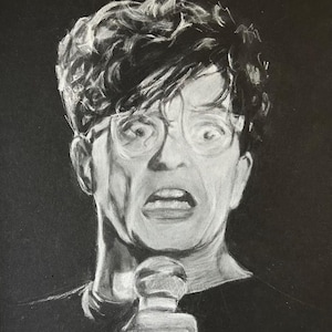 May include: A black and white drawing of a person with a microphone, wearing glasses and looking surprised.
