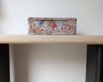 Caja de cerillas de metal con tapa, con motivo de querubines de la época victoriana.