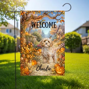 Könnte beinhalten: Eine rechteckige Gartenflagge mit einem hellbraunen Welpen auf einem Weg, umgeben von orangefarbenen Kürbissen, Herbstlaub und einer Laterne. Der Text WELCOME steht oben und der Name Charlie ist in Schreibschrift unter dem Welpen zu sehen.