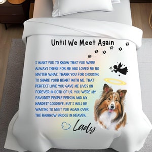 Puede incluir: Manta blanca con el texto "Until We Meet Again" y un poema. Presenta una ilustración de perro Sheltie, un ángel, huellas de patas y el nombre "Lady".