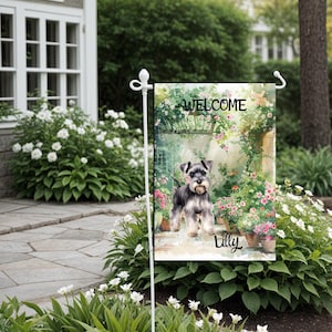 May include: A garden flag featuring a watercolour illustration of a miniature schnauzer dog standing in a garden setting. The flag has the text "WELCOME" and the name "Lilly" printed on it.
