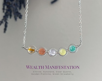 May include: A silver chain necklace featuring five circular settings, each containing a different gemstone: citrine, sunstone, clear quartz, golden prehnite, and green strawberry quartz. Text below reads: WEALTH MANIFESTATION Citrine, Sunstone, Clear Quartz, Golden Prehnite, Green Strawberry.