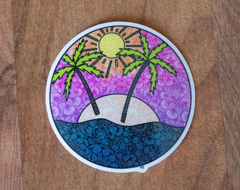 Puede incluir: Una pegatina redonda con una ilustración colorida de dos palmeras, un sol y una escena de playa. El fondo es un degradado de rosa, morado y azul.