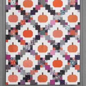 May include: A quilting pattern called "Pumpkin Patches" with a white background and a patchwork design of orange pumpkins, black and white squares, and pink and purple squares. The pattern is made with fat quarters, 5-inch squares, or 10-inch squares.