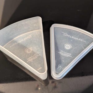 May include: Two clear plastic wedge-shaped containers with the word "Tupperware" printed on one of them.