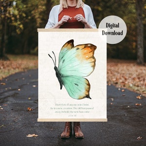 May include: A watercolor painting of a butterfly with a teal and orange color scheme. The butterfly is on a white background with the text "Therefore, if anyone is in Christ, he is a new creation. The old has passed away, behold the new has come. 2 Cor. 5:17" printed below.