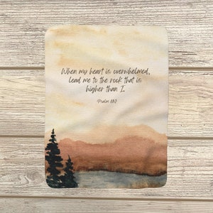 May include: A watercolour painting of a mountain range with a quote from Psalm 61:2, "When my heart is overwhelmed, lead me to the rock that is higher than I."