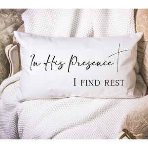 May include: White throw pillow with black text that reads "In His Presence I Find Rest".