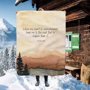 May include: A watercolour painting of a mountain landscape with a quote from Psalm 61:2, "When my heart is overwhelmed, lead me to the rock that is higher than I."