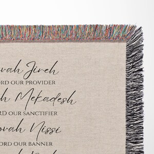 K&ouml;nnte beinhalten: Eine beige Decke mit schwarzem Schrifttext und einem Fransenrand. Der Text enth&auml;lt S&auml;tze wie "Jehovah Jireh" und "Lord Our Provider". Der Fransenrand weist eine Mischung aus Farben auf und verleiht der Decke eine dekorative Note.