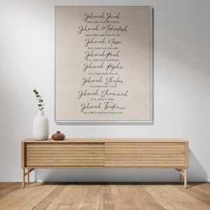K&ouml;nnte beinhalten: Ein gerahmter Leinwanddruck mit den Namen Gottes, darunter "Jehovah Jireh", in eleganter Schrift. Der Druck h&auml;ngt &uuml;ber einem Holzschrank mit zwei Schiebet&uuml;ren. Eine wei&szlig;e Vase und ein kleines braunes Dekorationsobjekt befinden sich auf dem Schrank.