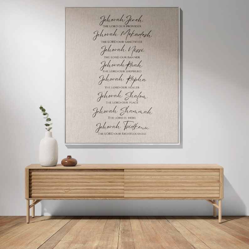K&ouml;nnte beinhalten: Ein gerahmter Leinwanddruck mit den Namen Gottes, darunter "Jehovah Jireh", in eleganter Schrift. Der Druck h&auml;ngt &uuml;ber einem Holzschrank mit zwei Schiebet&uuml;ren. Eine wei&szlig;e Vase und ein kleines braunes Dekorationsobjekt befinden sich auf dem Schrank.