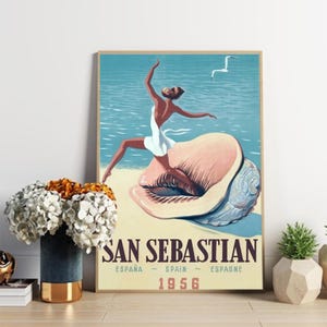 Könnte beinhalten: Ein Vintage-Reiseposter für San Sebastian, Spanien, mit einer Frau in einem weißen Kleid, die auf einer großen Muschel steht. Das Poster ist in einem blauen, rosa und weißen Farbschema gehalten und enthält den Text "San Sebastian, España - Spain - Espagne, 1956".