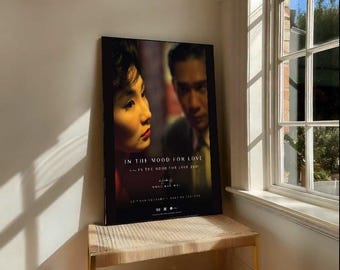 May include: A framed movie poster for "In the Mood for Love" featuring two people in a close-up shot. The poster is displayed on a woven bench with gold legs, near a window with sunlight.