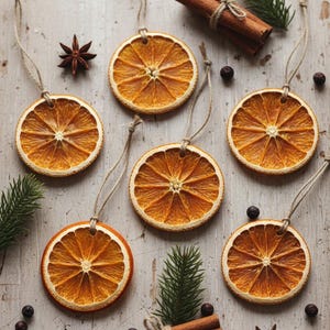 May include: Dried orange slice decorations with twine hangers, arranged with star anise, cinnamon sticks, and evergreen sprigs. The orange slices are a warm orange colour, and the cinnamon sticks are tied with twine.