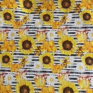 May include: A seamless fabric pattern featuring yellow sunflowers, honeycombs, and bees on a white and black striped background.