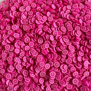 May include: A close-up shot of a pile of small, pink polymer clay slices shaped like citrus fruit. Each slice has a white rind and a detailed interior, creating a vibrant and textured appearance. These decorative pieces are ideal for crafting and jewelry making.