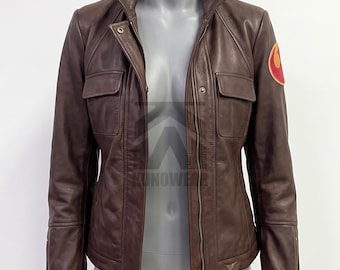 May include: A brown leather jacket featuring a central zipper closure, a high collar, and two chest pockets with flaps. The left sleeve displays a circular orange and red Rebel Alliance emblem. The jacket has long sleeves with zippered cuffs.