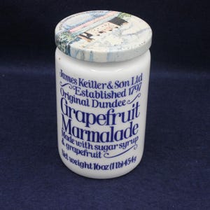 Può includere: Vasetto bianco di marmellata di pompelmo con coperchio decorativo. Il vasetto ha un testo blu che recita "James Keiller & Son Ltd, Established 1797, Original Dundee, Grapefruit Marmalade." Peso netto 454g.