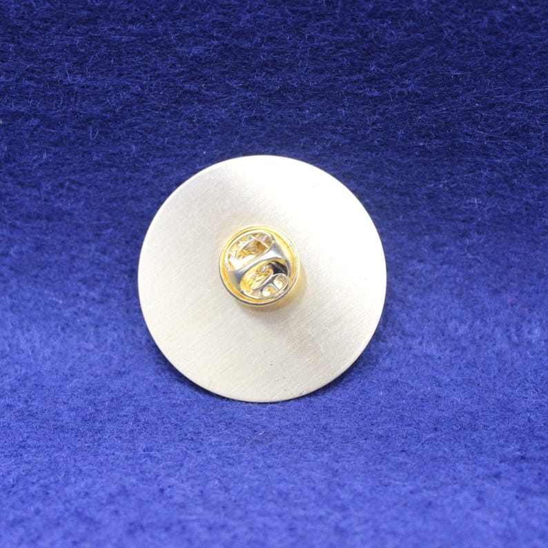 Rear of Guiness badge on a blue background